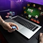 Young man play online poker in laptop.